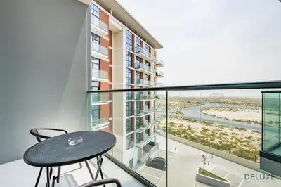a balcony with a table and a view of the beach at Cosmopolitan 1BR Apartment in Celestia B, Dubai South by Deluxe Holiday Homes in Dubai