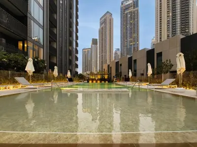 a large pool of water with umbrellas in a city at Creek Gate by Emaar, Dubai Creek Harbour in Dubai