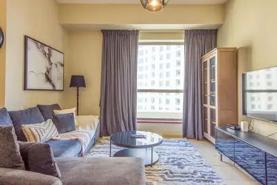 a living room with a couch and a tv at Two-Bedroom Apartment with Balcony in Shams 4, JBR in Dubai