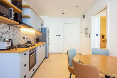 a kitchen with a wooden table and a dining room at Collective 2,0 Dubai Hills- Attractive 1-BR in Dubai