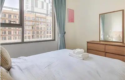 a bedroom with a white bed and a large window at Park Heights, Dubai Hills- Cozy 1-BR in Dubai