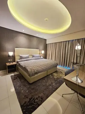 a bedroom with a large bed with a yellow ceiling at 1 Bedroom Apartment Paramount in Dubai
