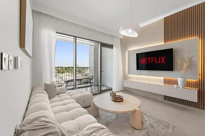 a living room with a couch and a tv at Chic 1BR Retreat - Near Burj Khalifa & Dubai Mall in Dubai