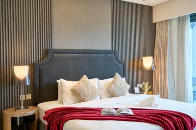 a bedroom with a large bed with two books on it at Luxurious 2BDR Apartment in Paramount Towers with Burj Khalifa Views in Dubai