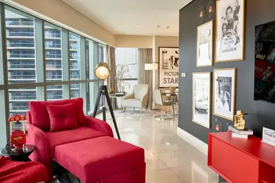 a living room with a red chair and a red couch at Luxurious 2BDR Apartment in Paramount Towers with Burj Khalifa Views in Dubai