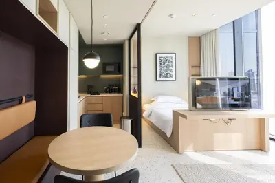 a small room with a bed and a desk and a table at Modern Studio at Upside Living, Business Bay with Burj Khalifa View in Dubai