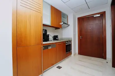a kitchen with wooden cabinets and a wooden door at Stunning Luxury Studio Downtown 2 Minute Walk to Burj Khalifa & Dubai Mall in Dubai