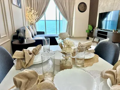 a living room with a dining table with a view of the ocean at Skyline View Premium Apartment in Dubai