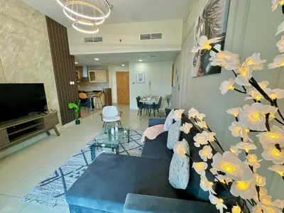 a living room with a blue couch and a tv at Skyline View Premium Apartment in Dubai