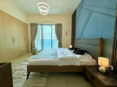 a bedroom with a large bed with a large window at Skyline View Premium Apartment in Dubai