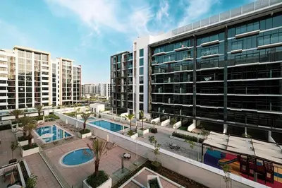 a large building with two pools in front of it at Elegant Studio with Terrace 7 min Burj Khalifa in Dubai