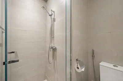 a shower with a glass door in a bathroom at Elegant Studio with Terrace 7 min Burj Khalifa in Dubai