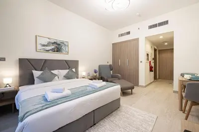 a bedroom with a large bed and a desk at Elegant Studio with Terrace 7 min Burj Khalifa in Dubai