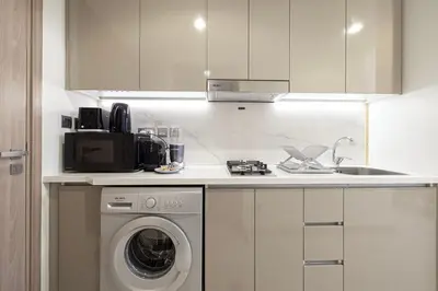 a kitchen with a washing machine and a sink at Elegant Studio with Terrace 7 min Burj Khalifa in Dubai