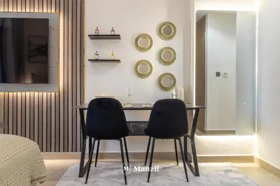 a dining room with two chairs and a table at Manzil - Studio Apartment in Azizi Riviera near Dubai Mall in Dubai