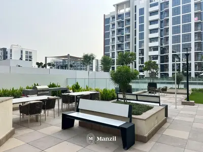 a patio with tables and chairs and buildings at Manzil - Studio Apartment in Azizi Riviera near Dubai Mall in Dubai