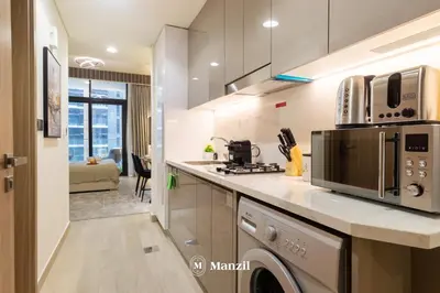 a kitchen with a stove and a microwave at Manzil - Studio Apartment in Azizi Riviera near Dubai Mall in Dubai