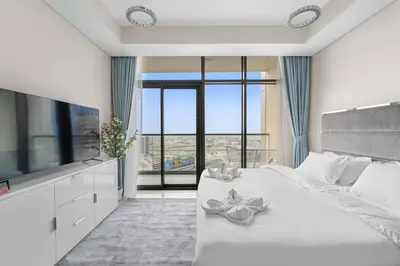 a bedroom with a large white bed with flowers on it at FIRST CLASS Studio Luxe Living in Dubai