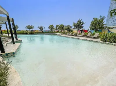 a large swimming pool with chairs and water at FIRST CLASS Studio Luxe Living in Dubai
