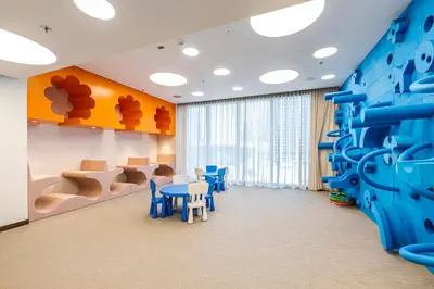 a room with a climbing wall and a table and chairs at 1BR Forte II Downtown View in Dubai