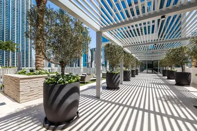 a walkway with rows of potted trees on a building at 1BR Forte II Downtown View in Dubai
