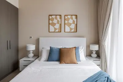 a bedroom with a large white bed with two lamps at 1BR Forte II Downtown View in Dubai
