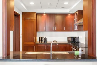 a kitchen with wooden cabinets and a sink at Bellavista - 29 BLVD - 1 Bedroom Burj Khalifa & Fountain View in Dubai