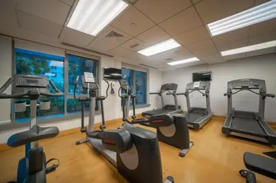 a gym with several tread machines in a room at Bellavista - 29 BLVD - 1 Bedroom Burj Khalifa & Fountain View in Dubai