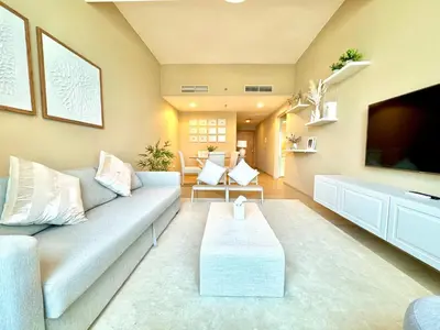 a living room with a couch and a tv at Urban Oasis Stylish JLT Apartment with Lake Views in Dubai