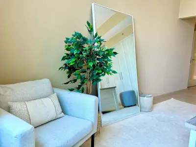 a living room with a couch and a mirror at Urban Oasis Stylish JLT Apartment with Lake Views in Dubai