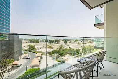 a balcony with chairs and a view of a city at Charming 1BR Apartment in Downtown Views 1, Downtown Dubai by Deluxe Holiday Homes in Dubai