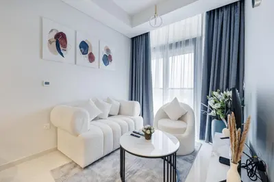 a white living room with a couch and a table at ALiving Charming 1BR I Aykon City Tower, Business Bay in Dubai