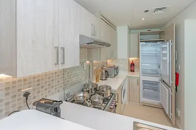 a kitchen with white cabinets and a refrigerator at Beach access I Sea View I Infinity pool in Dubai