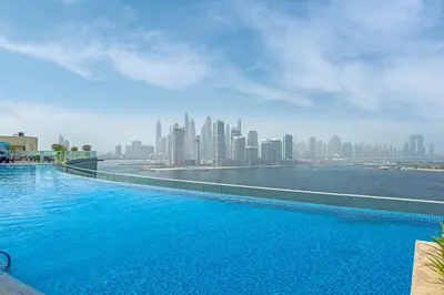 a large swimming pool with a view of a city at Beach access I Sea View I Infinity pool in Dubai