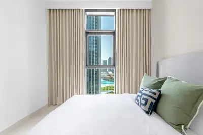 a bedroom with a white bed and a large window at Stunning 3 Bedroom Apartment with Fountain Views by ZEN STAYS - Sleeps 9 - 2 Balconies in Dubai