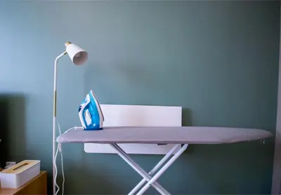 a desk with a lamp and a blue wall at Sky View, Furnished, FreeParking in Dubai