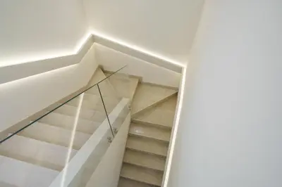 a staircase in a house with glass railing at Backyard Bliss Villa in The Lakes 3BR plus maid's room in Dubai