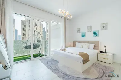 a white bedroom with a large bed and a large window at Sophisticated 1BR Apartment in La Vie, Jumeirah Beach Residences by Deluxe Holiday Homes in Dubai