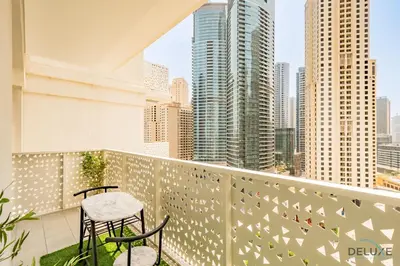 a balcony with two chairs and a view of the city at Sophisticated 1BR Apartment in La Vie, Jumeirah Beach Residences by Deluxe Holiday Homes in Dubai