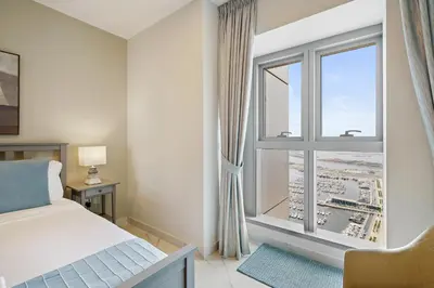 a bedroom with a bed and a large window at Sky Haven in 45th Floor 2BR with Dubai Harbour Views in Dubai