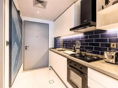 a kitchen with a stove top oven next to a door at MAG318 Downtown Luxury - 5 Min Walk to Burj & Mall in Dubai