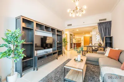 a living room with a large entertainment center at Charming 1BR Apartment at Ocean Heights Dubai Marina by Deluxe Holiday Homes in Dubai