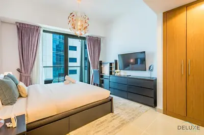 a bedroom with a large bed and a tv at Charming 1BR Apartment at Ocean Heights Dubai Marina by Deluxe Holiday Homes in Dubai