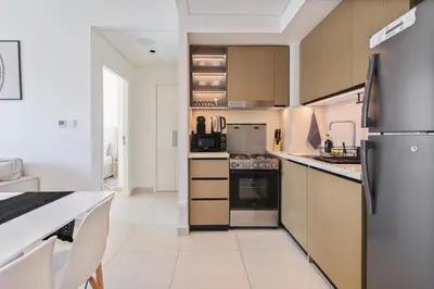 a kitchen with stainless steel appliances and wooden cabinets at Sea & City Views - Burj Crown - 5 Min Walk to Mall in Dubai