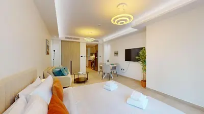 a bedroom with a bed and a living room at Primestay - Elevated Studio in JLT - Dubai in Dubai
