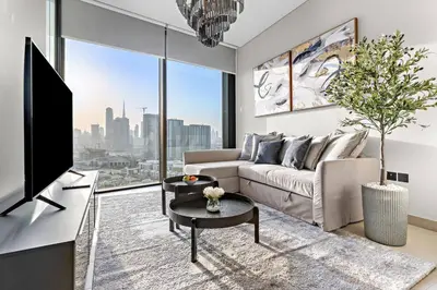 a living room with a couch and a tv at FIRST CLASS Luxury 1BR plus Bunk Room in Sobha Waves, Close to Downtown Dubai in Dubai