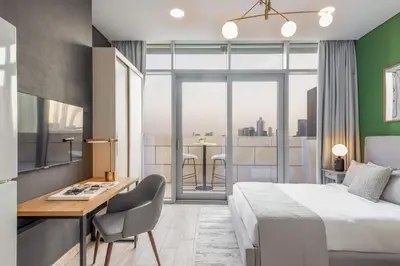 a hotel room with a bed and a desk and a window at Silkhaus Burj Khalifa View Studio in Iconic Tower in Dubai