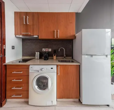 a kitchen with a washing machine and a refrigerator at Silkhaus Burj Khalifa View Studio in Iconic Tower in Dubai