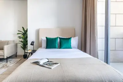 a bedroom with a bed with a book on it at Silkhaus Modern Studio with Balcony in Burj Daman in Dubai