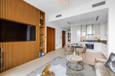 a living room with a tv and a table with chairs at Daniels 1BR Marina Horizon Retreat in Dubai